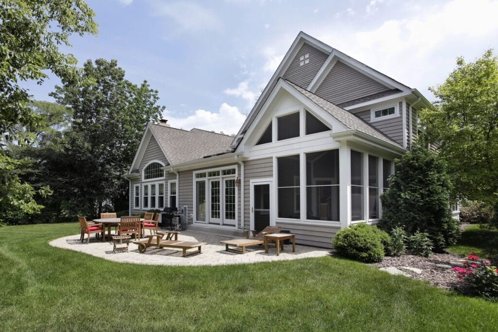 Rear view of luxury home with brick patio